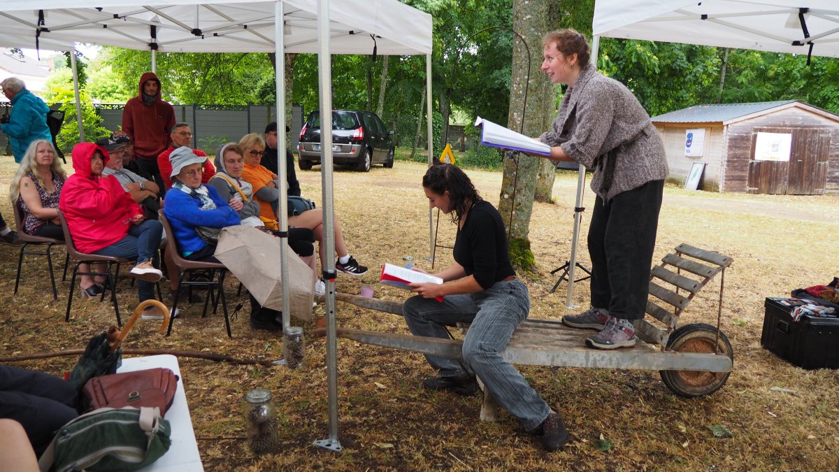 Les deux comédiennes lisent le texte du spectacle de théâtre de rue "J'ai toujours aimé le feu" sous la pluie